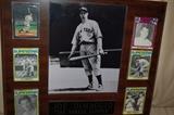 Framed Joe DiMaggio photo surrounded by baseball cards.


