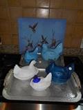 Kitchen:  A flock of glass roosters; a painting on canvas; one of two aluminum  trays.