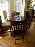 Music Room:  A round counter-height table (also has one leaf) and four counter height  chairs.  The table is 42" round (the extra leaf is 18 inches wide) and stands 36" tall.