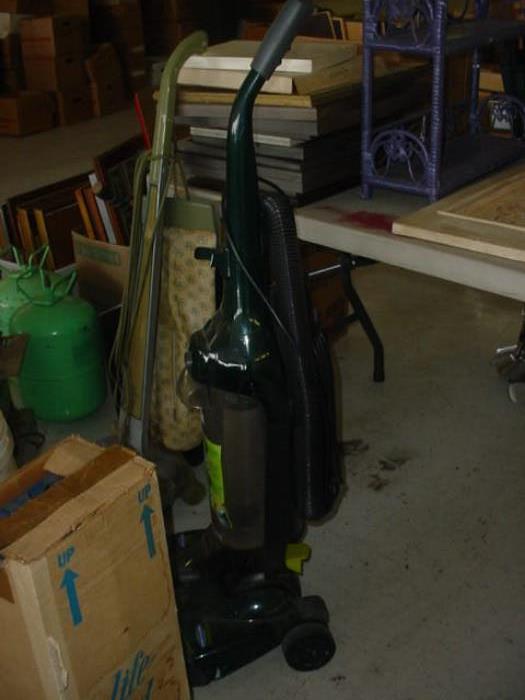 Several vacuum cleaners, rug shampoo machines, and cleaning supplies