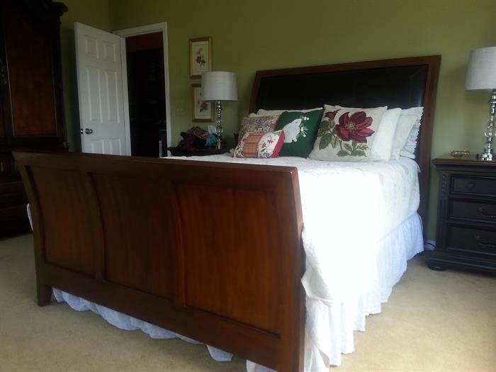 Queen size sleigh bed with black leather on headboard