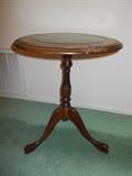 Three leg accent table with leather inset panel.