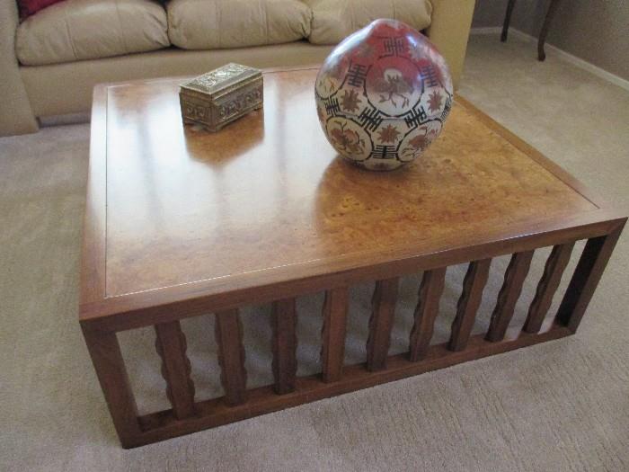 This large coffee table has a dynamic burlwood top surface
