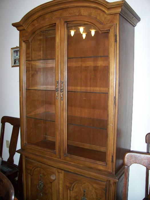 Lighted china hutch with adjustable glass shelves and storage underneath.