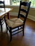 8 Black Ladderback chairs with rush seats