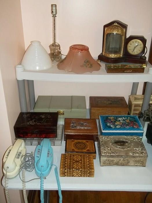 Lots of interesting vintage jewelry boxes, plus princess phones and antique ceiling light covers. At top right is United clock.