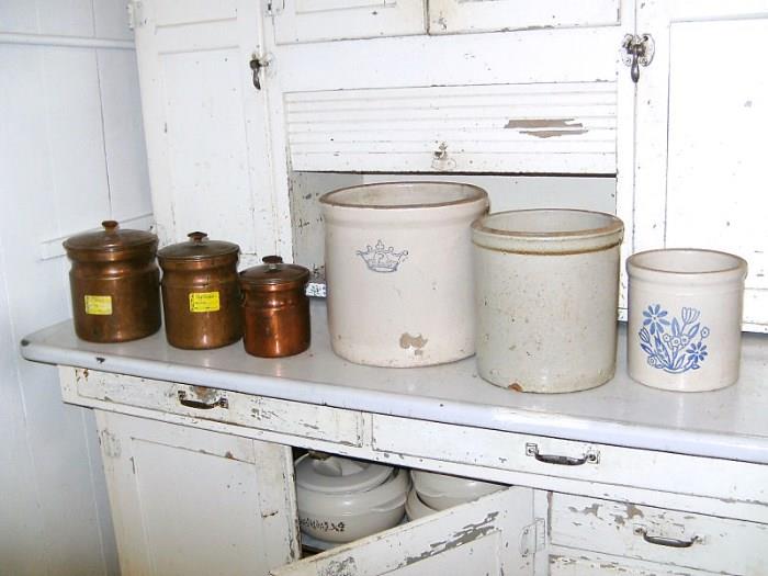 Copper canisters and stoneware crocks.