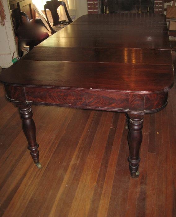 Mahogany D end dining table with unusual accordion action expanding base.With all 6 leaves, table is 9'10" long. With no leaves, table is a nice 45" square table.Top can also be folded to make a console table.