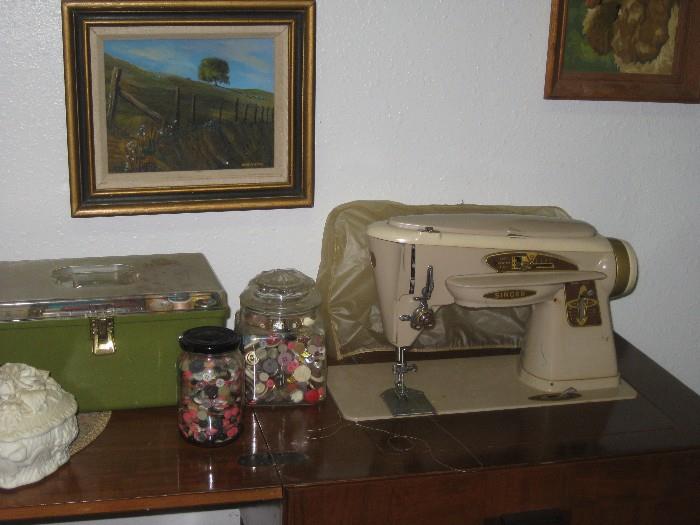 Singer sewing machine and cabinet along with several sewing baskets and notions