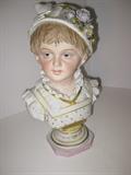 32.	German Bisque Bust of Girl, circa 1920     Appraisal Est. $750
Bisque fired porcelain bust of a young girl, with a serene gaze, apparently of German origin. Blonde with blue eyes, dressed in the typical “Heidi” outfit. Marked ON/114 and “500/8” and signed R. Moller. Stands 13-1/2” tall, 8-1/4” wide, x 6-1/4” deep.

