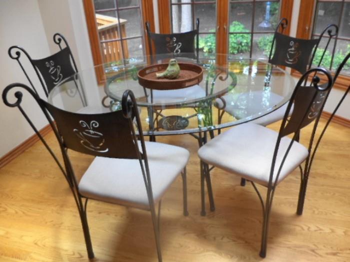 Wrought iron glass top pedestal table with "expresso" motif on chairs