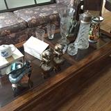 Unique mug, book ends, wedgewood china, gold leaf glasses, etched vase, matching colorful vase on top glass coffee table.