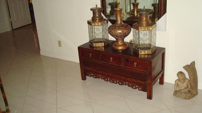 small Asian chest topped with brass lanterns