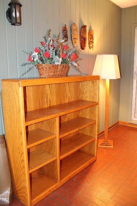Oak office bookcase, wooden masks, craftsman style floor lamp and vintage silk floral arrangement