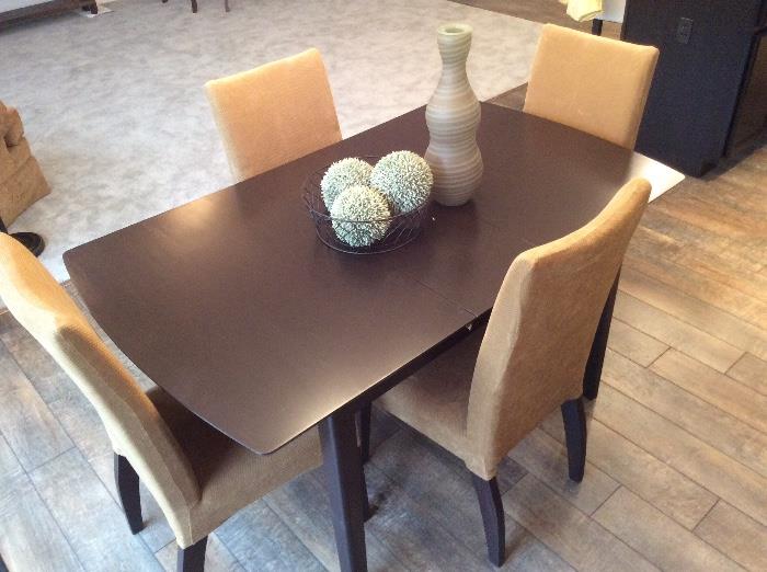 Dark stained dining table with tan parsons.