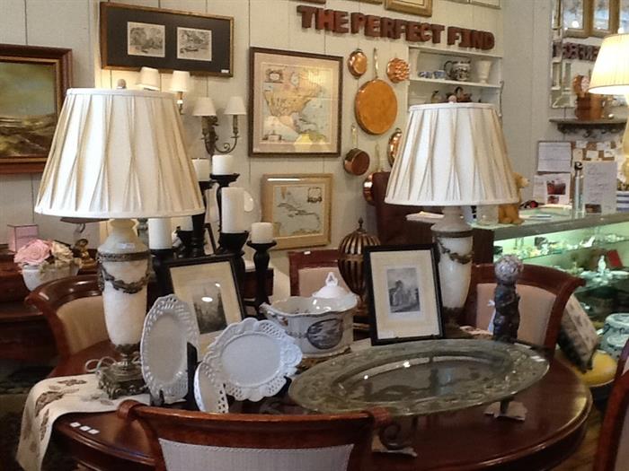 Alabaster and bronze lamps, large glass serving tray, small white decorative dishes, decorative tureen on bronze base, Theodore Alexander bronze cherubs with marble ball on granite base