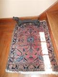 Oriental rug and iron dog-shaped boot scraper