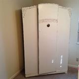 Armoire with two bars for clothes storage. Inside door is the original mirror, hanging bar and maker's label.