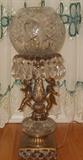 Brass cherub base lamp with crystal globe and hanging crystal prisms.