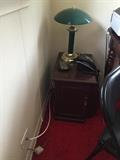 Dark wood nightstand, green table lamp