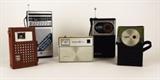 Item Description: A wonderful collection of portable transistor radios including a cream colored Westinghouse Escort-8 model RS21PO8A, a black and silver General Electric FM/Am Sound 24 hr. weather radio, model 7-2934A, a Jade model 1166-2 made in Hong Kong, comprised of green plastic with a nice vinyl case, a Magnavox 7 Am radio in a brown leather case, model 2-AM-70 made in Japan and a black Sanyo Am/FM pocket radio model RP5050.
