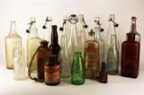 Item Description: A large grouping of primitive glass bottles including six clear glass bottles with stoppers, several medicine bottles with embossed wording, such as Cod Liver Oil and Malydor from Lancaster Ohio, a Green Rolling Rock bottle, a corked brown glass bottle with pealing label that says "Compressed tablets Sodium Salicylate" and a cool almost full bottle of A.D.S. Hair Reviver plus many more.
