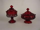 Item Description: Two beautiful Depression ware red ruby glass lidded compotes including a Fostoria coin lidded pedestal dish adorn with frosted American Eagle and coin Liberty torch coins. Also included a compote with scalloped petal like rim embellished with hobnail ornament and matching lid.
