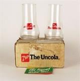 Item Description: A unique pair of vintage 7 Up glasses that look like they are upside down, marked on one side with "7up" upside down - the other side says "the Uncola", still packaged in the box they were shipped in.

