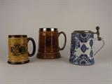 Item Description: An interesting collection of beer mugs including a mug with a crackle finish, depicting a Horse and buggy scene, a Lord Nelson Pottery from England mug with a humorous design and a blue and white stein from Germany.
