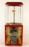 Item Description: A retro bubble gum machine comprised of glass and red painted metal with gold colored front, marked 25 cents. 
