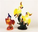 Item Description: Two lovely vintage Majolica style porcelain parrot figurines, one features two yellow parrots perched on a branch, the other is a single colorful parrot with a pink flower.
