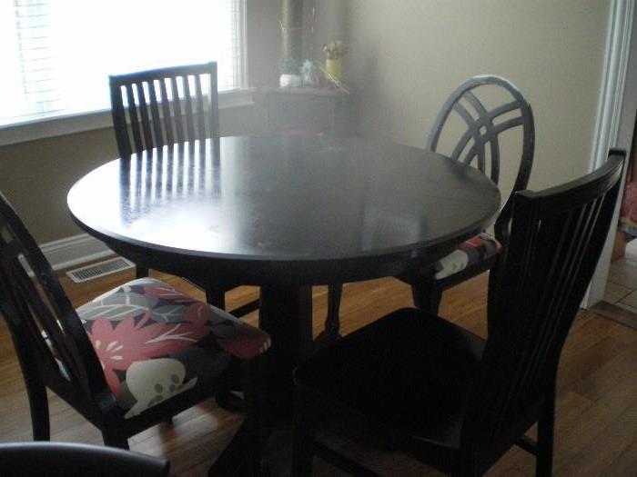 45" round Black Crate & Barrel Kitchen table with 1 additional leaf and 4 chairs