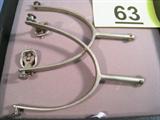 Pair of Vintage Silver Metal Cowboy Spurs Great pair of western cowboy horseback riding spurs, missing leather strap. Has original buckles, each is stamped on back with partial maker hallmark. Measure 5.5" length x 4" width.