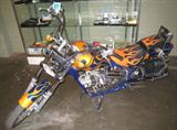 Johnny Pag Creations "Mini Harlee" Motorcycle Mini Harlee motorcycle made by Johnny Pag Creations, has cushioned black and orange seat with stitched flame designs. Powered by a 50cc single-cylinder four-stroke engine, manual 4-speed clutch. It uses drum-type brakes on both the 17-inch front and 12-inch rear wheels, and carries just under two gallons for fuel in the shapely fuel tank. Has metallic navy blue color with green outlined orange flame body, stated to be the "Ghost Rider" design by original consignor.
Front fender has damage near back of wheel, otherwise this bike runs well!
VIN #: 1J9RR11533C273194