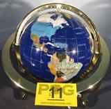 Art Gemstones of the World Globe
An absolutely breath taking Gemstone Globe. The hand crafted sphere has been inlaid with semi-precious stones according to geographic location. The globe is displayed on a three legged brass color stand with a compass in the bottom center. Some of the stones and the country they represent are:
 - Rich Jade, Russia.
 - Lilac, Pakistan
 - Yellow Jade, Saudi Arabia
 - Turquoise, United States of America
 - Tigerish, South Africa
 - Aventurine, India
 - Red Jasper, Mongolia
 - Many others
This globe measures approximately 14" tall and 12" in diameter.