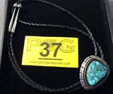 Jewelry Sterling Silver Turquoise Bolo Tie / Bola
Handsome southwestern style large oval bolo is marked "Sterling" and is adorned with a large oval cut turquoise stone. Bolo is supported on black leather tie. Measures 36".
Total weight: 1.90 ozt.