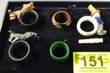 Mixed Lot Napkin Rings & Meerschaum Pipe Stem
Mixed lot of vintage items include:
 - Wooden napkin rings with carved Scottie dog figures.
 - Glass napkin ring with a clown figure.
 - Green resin napkin ring, possibly bakelite.
 - Carved resin pipe stem, appears to be Meerschaum.