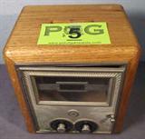 Vintage Post Office Box Door Wooden Bank
An innovative carpenter has converted a vintage post office box door into a bank. The wooden box has a slot on top for coins or bills. The front of the box is a metal door with two alphabetical dials and a glass window.
Bottom of box has a lock mechanism but no key is present. Measures 7" tall x 7.5" wide and 6" deep.