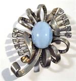 Jewelry Silver & Blue Chalcedony Floral Brooch
Lovely & sizable sterling silver brooch featuring a pale blue chalcedony / quartz stone, oval shaped, in a four prong style setting, accentuated by several loops & sprays of sterling silver embellishments with white / clear rhinestones / pastes, forming the shape of a beautiful flower, completed by a back bar pin. Measures 3" x 2" (est).
Total weight: 1.60 ozt
