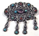 Jewelry Sterling Silver & Colorful Stones Brooch
Beautiful ladies brooch, Southwestern style, sterling silver featuring several small turquoise & coral stones spaced around a small purple stone, possibly amethyst, in the center. Also has four dangling charms each featuring a small turquoise stone. Beautiful filigree style design throughout the brooch, with a traditional bar pin clasp at the back. Marked / signed "Mexico TM-149". Measures 2.25" across (est)
Total weight: 0.70 ozt