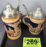 Lot of 2 Gerz Steins with Pewter Lids
Lot of 2 vintage lidded stein marked on the base with the Gerz ink stamp. Each thumb style lid has a dgbm stamp on the underside. Lot includes:
- Vividly colored stein depicts three characters making merry as they enjoy their beverages. There are no quotations on this stein. Measures 6.5" tall.
- Beautifully decorated stein depicts three characters and a fox like animal sitting at a table. Stein has two quotations, "Kuhler Trunk" and "Und Heibe Jadg". Measures 7.25" tall.