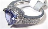 Jewelry 14kt White Gold Tanzanite & Diamond Ring
Elegant 14kt white gold ring with Tanzanite and diamond stones. Included GLA Premium Appraisal reads: "One lady's polished, stamped and electronically tested solid 14kt white gold ring mounted with: 1 Genuine Tanzanite and 59 genuine Round Single Diamonds. This item weighs 4.72 grams and fits a finger size 7.25. The setting measures 10.97 x 11.09 mm and the band measures 4.10 mm tapering down to 2.61 mm at the center of the shank. The condition is brand new. The gemstones have been analyzed in the mounting.
Main Gemstone:
Identity: Genuine Tanzanite (Zoisite)
Cut: Trillion (faceted)
Dimensions: 8.03 x 8.16 mm (est.) (no depth)
Quantity: 1
Carat Weight: 1.89 cts (est)
Clarity Type: I=Variety flawless-near flawless
Hue: Violet Blue
Transparency: Transparent
Tone: Medium
Saturation: Vivid-Bright
Polish: 9-Excellent
Finish: 6-Good-Very Good
Quality: 8-Very Good to Excellent
Adjacent Gemstones:
Identity: Genuine Diamond
Cut: Round Single (fac