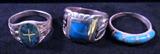 Jewelry Lot of 3 Southwest Silver Turquoise Rings
Lot of 3 Southwestern style ladies rings:
- Lovely sterling silver ring featuring 4 rounded square cut turquoise stones stationed & raised along the band, spaced between thin bars of sterling silver. Simple & pretty. Size 10.25
- Stout sterling silver ring featuring turquoise square cut stone embellished with sterling silver wing designs flanking either side of the stone. Stately & lovely. Size 9.25.
- Beautiful sterling silver ring featuring an oval setting with multiple flecks of turquoise, thin silver cross inlaid. On one side of the stone is an engraved silver cross, thicker than the one inside the turquoise itself, and on the other side is a Southwestern style flying eagle engraved in the silver. Size 11.
Total weight: 0.61 ozt