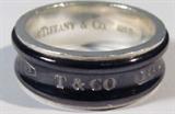 Jewelry Tiffany & Co Men's Sterling Silver Ring
Fantastic sterling silver Tiffany & Company men's ring, with inlaid gunmetal colored band on the outside with silver engraving "NY T&Co 1837", marked / signed "Tiffany & Co 925 Ti" on inside of the band. Fits a finger size 10.