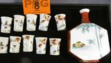 Oriental Sake Set Decanter & 10 Lithophane Cups
A fantastic hand painted porcelain Japanese Sake / Cordial set which includes the decanter and 10 cups. All pieces are signed with the same Oriental mark. The cups are exceptional with a lithophane bottom featuring the face of a Geisha. The decanter measures 6" tall. Each cup is 1.75" tall.