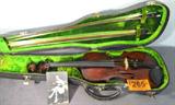 Vintage Violin w/ Hard Case & 1924 Photograph
A beautiful vintage four string violin. Bridge is marked, "Aubert - Czechoslovakia". Chin rest is marked "Made in Germany". Hard back case contains 2 bows, each with mother of pearl inlaid accents on the handles. A sepia photograph of a young girl holding a violin, possibly this violin, is also included inside the case. The photo is captioned, "Medy - 1924". The back of the scroll has several small age cracks in the wood. One corner of the purfling appears to have a repaired crack in the wood. Case shows some sign of wear due to age and use.