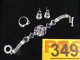 Jewelry Sterling Silver Bracelet, Ring & Earrings
Gorgeous sterling silver bracelet, earrings, and ring set featuring purple colored gemstones, possibly amethyst stones. Bracelet is completed by bar and ring style clasp. Marked "925", total weight: 1.23 ozt.
Bracelet measures: 7.25" long, ring size: 7.25.
