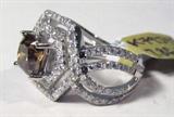 Jewelry 18kt White Gold Brown Diamond Ring
Fantastic 18kt white gold brown and white diamond ring, size: 6.75. Included AIG Pre-Sale Estimated Retail & Gemological Report reads: "One electronically tested 18kt white gold ladies cast diamond unity ring with bright finish. Condition is new, good workmanship. The featured diamond is set within a double hexagonal diamond bezel, supported by diamond set ribbons, completed by a three millimeter wide band. Trademark is HANA. Identified with markings of "18k". Containing: One prong set cushion cut diamond, measuring 6.77 x 6.05 x 4.64mm exact weight 1.69ct. Graded loose prior to setting in the EGL Laboratory, Report #US904187511D.
Clarity: SI-2
Color: Fancy Brown
Depth: 76.7%
Table: 58.0%
Pavil. Depth: 47.3%
One hundred twenty prong set round brilliant cut diamonds, measuring 1.30-1.30 x 0.78mm (depth est.) approximate total weight of 120 stones = 0.95ct. Graded in the setting.
Clarity: SI-2 to I-2
Color: G-H
Total weigh of Diamonds: 2.64ct.