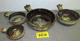 Set of 4 Southwestern Glazed Pottery Nesting Bowls
A set of 4 glazed pottery bowls that appear to be hand painted. The dark brown bowls are decorated in bold southwestern style colors and designs. They each have a single handle with a hole in the center that could be used to hang them. The bowls measures from 5" to 9" in diameter.