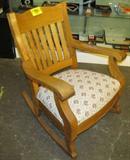 Furniture Oak Rocker w/ Needlepoint Cushion Seat
A quaint mission style oak rocker with needlepoint cushion. Appears to be made of solid oak with vertical slat back and curved end side arms. Measures 34" tall x 25" across x 30" in depth. Shows signs of wear from age and use.